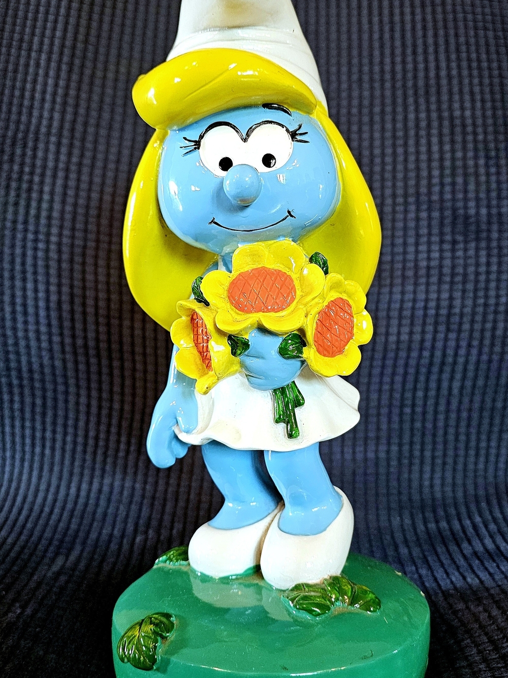 Blue Smurf Figurine with Yellow Hat and Sunflowers